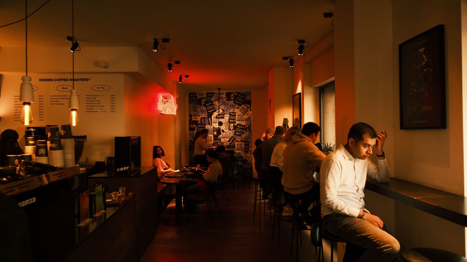 A cozy café in Barcelona showcasing modern decor and social ambiance with warm lighting and casual seating.