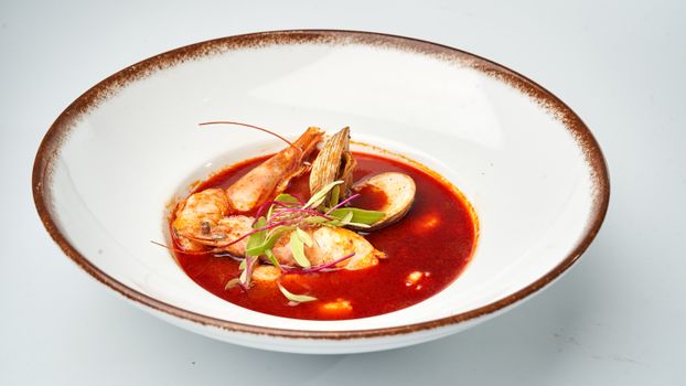 Delicious seafood soup with shrimp and mussels served in a white bowl, ideal for culinary projects.