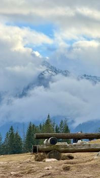 Scenic mountain landscape with clouds and rustic wooden fence.