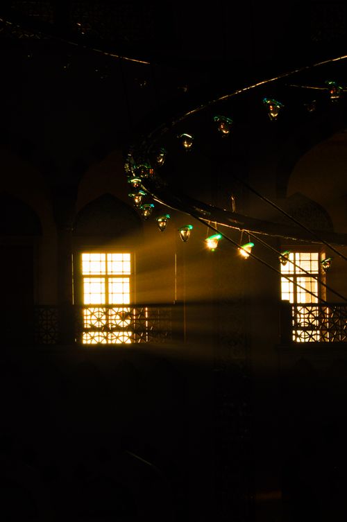 Free Sunlight streams through windows illuminating a room with decorative string lights. Stock Photo