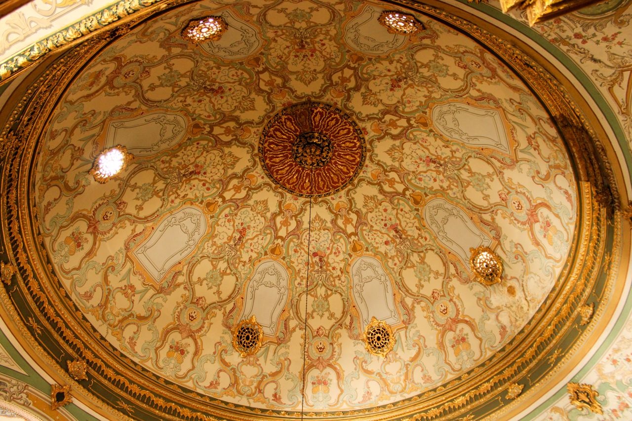 an ornate domed ceiling showcasing intricate patterns and warm gold to