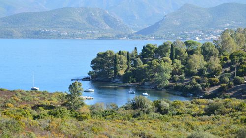 Free A tranquil coastal scene in France with boats and lush greenery. Stock Photo