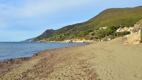 Free Peaceful coastal view of Farinole beach, surrounded by lush hills in Corsica, France. Stock Photo