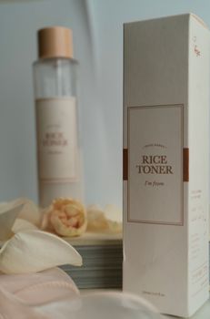 Aesthetic setup of rice toner and packaging with beige and white tones.