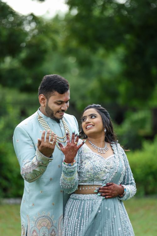 Free Smiling couple celebrates engagement outdoors in stylish, traditional attire. Stock Photo