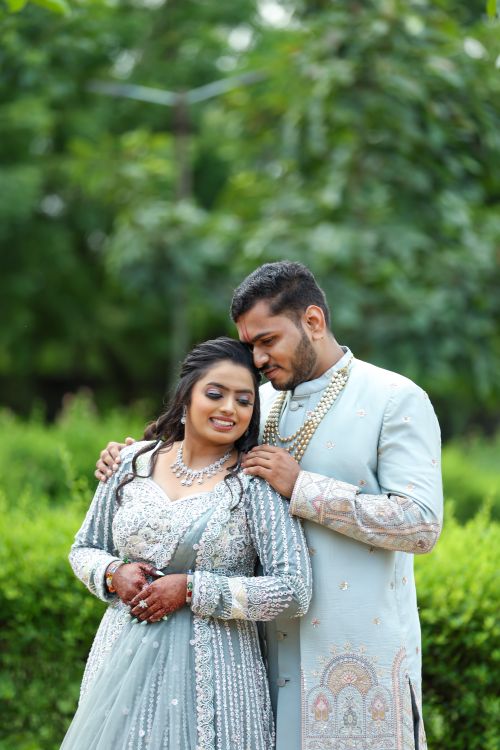 Free A romantic wedding portrait of a couple in ornate attire in a lush garden setting. Stock Photo
