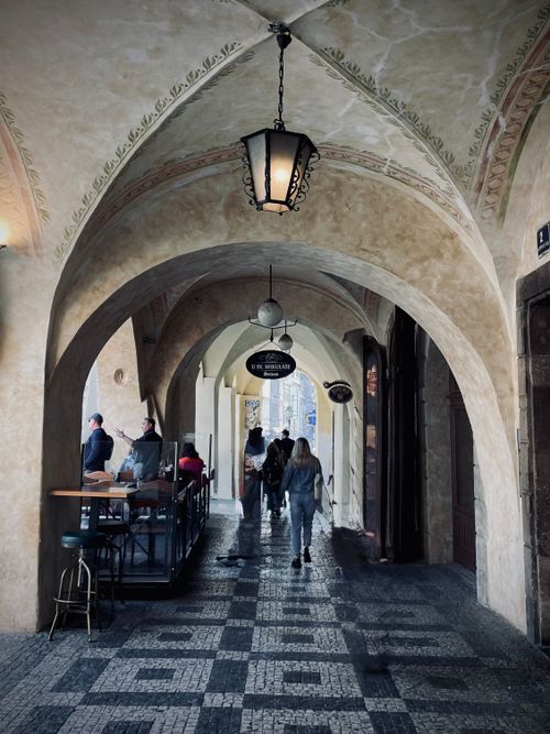 Free Historic European passageway with arched ceilings and patrons at a sidewalk café. Stock Photo