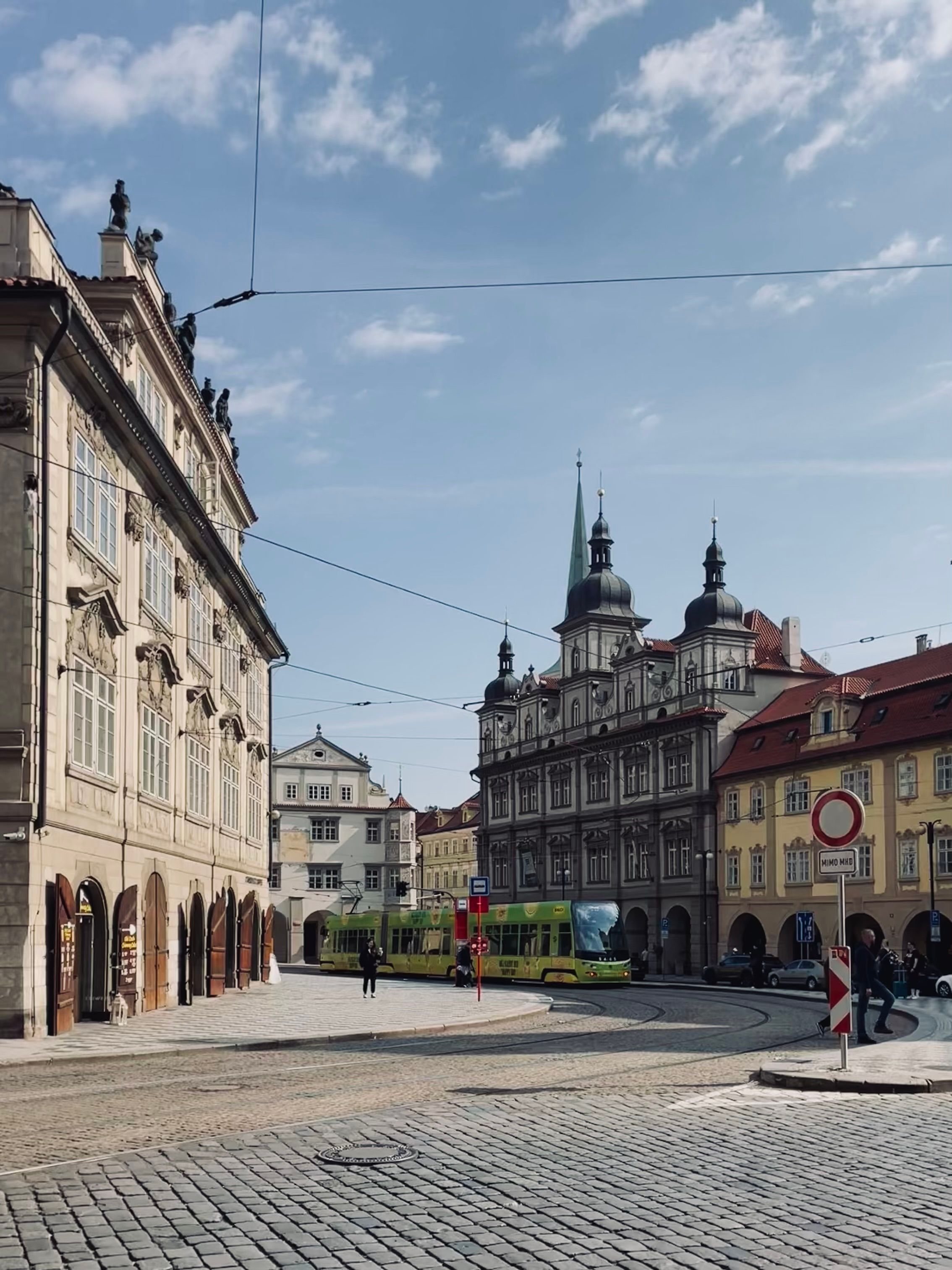 Charming street scene of a European town square with historic buildings and a tram.