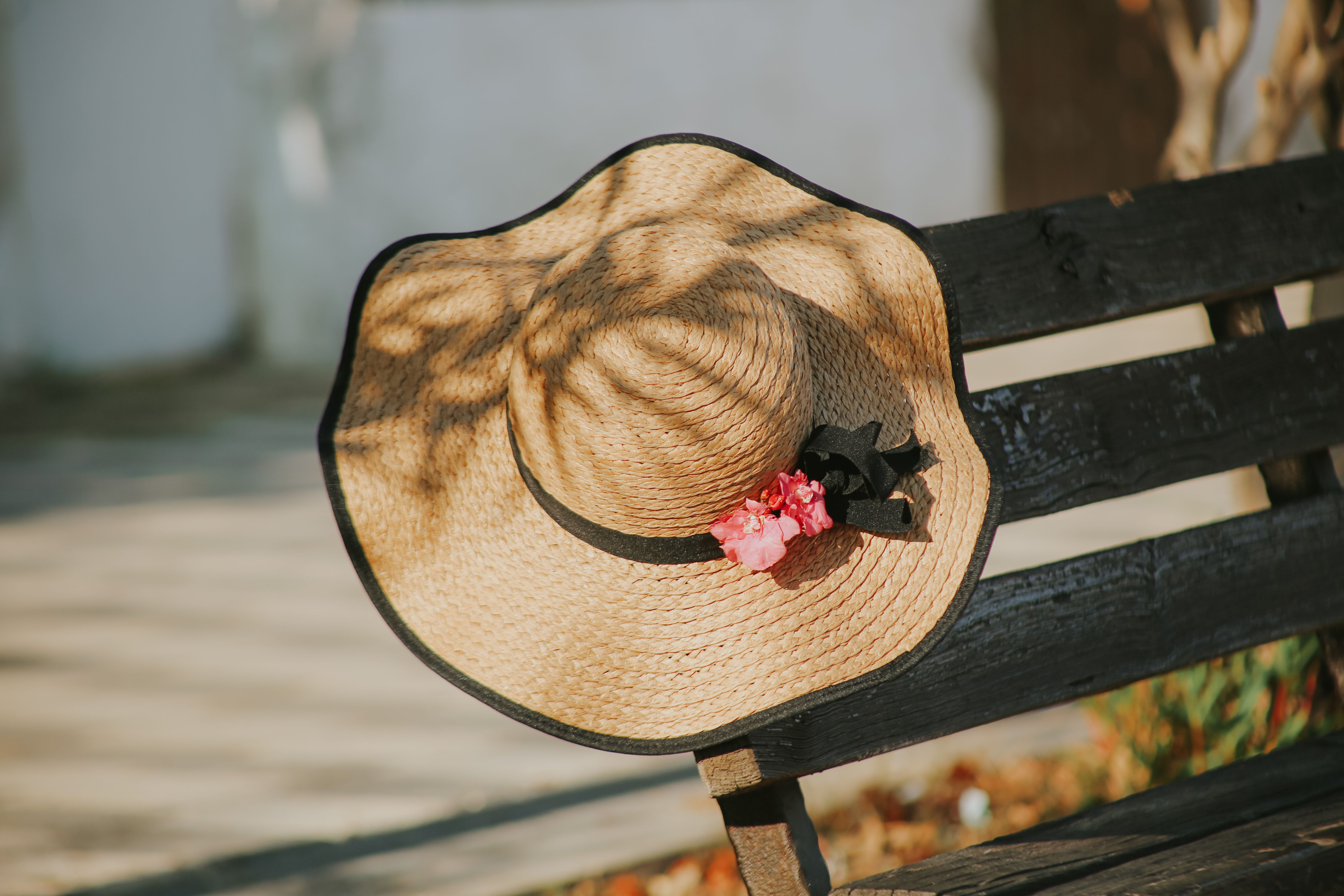 Straw Hat on Bench in Sunny Outdoor Setting · Free Stock Photo