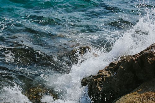 Free Waves crashing against rocks create a dramatic ocean scene. Stock Photo