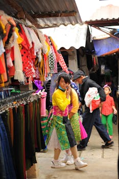Vibrant market scene showcasing traditional clothing styles in a bustling outdoor setting.