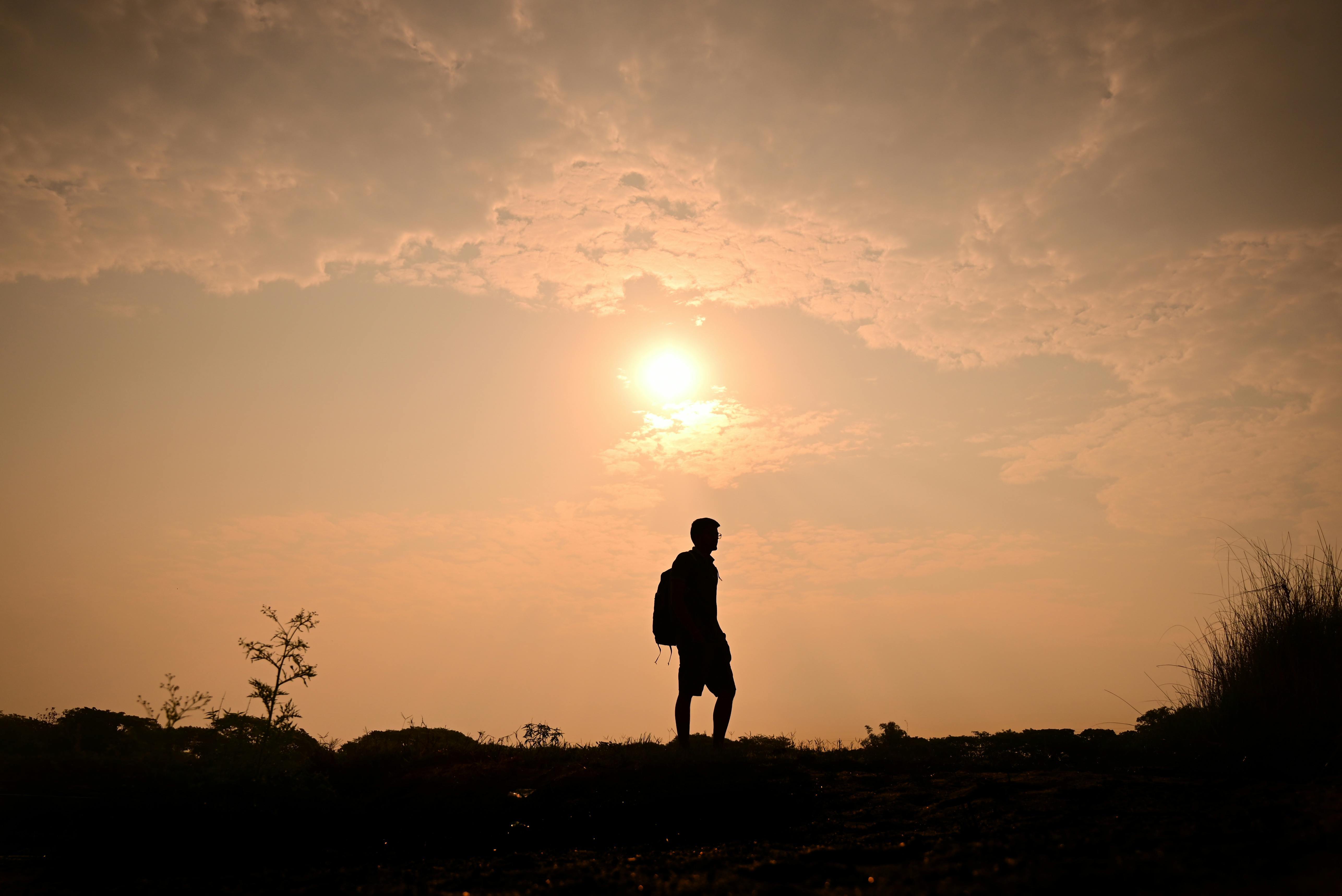 Capture of a lone traveler silhouetted against a vivid sunset sky.