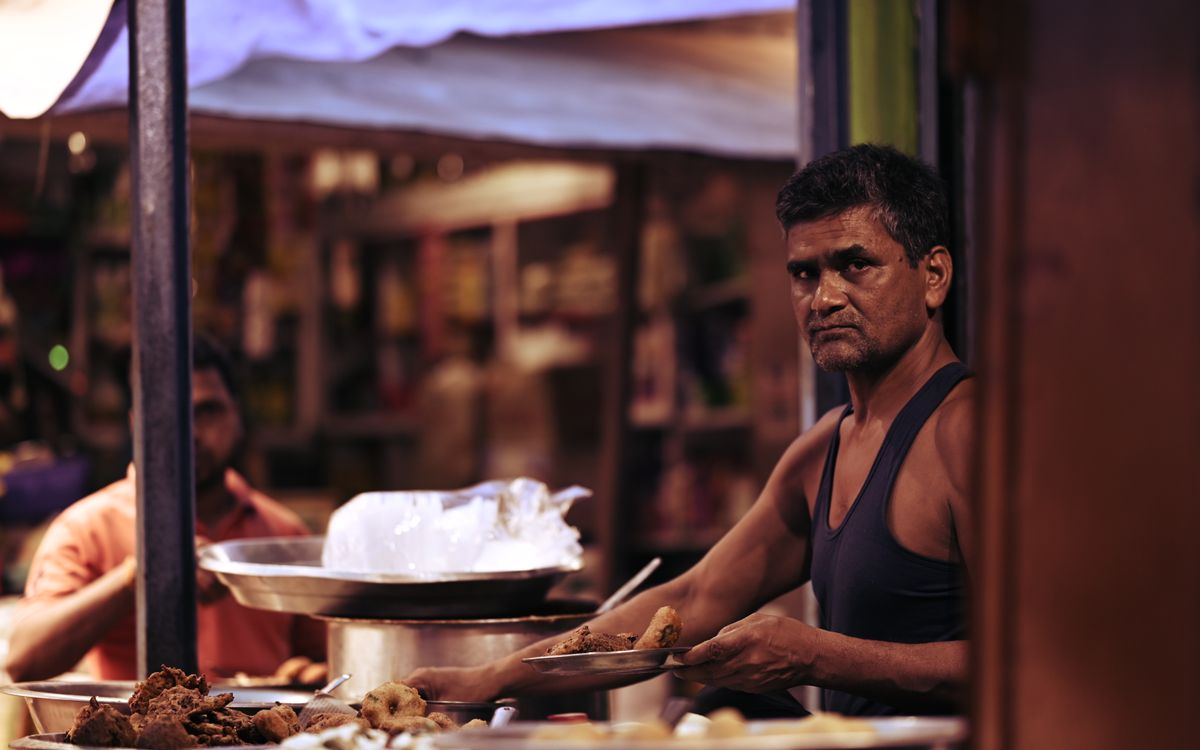 Indian street food vendor preparing snacks at a night market
