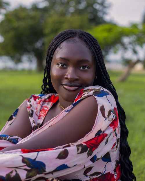 Free Portrait of a smiling woman in a floral dress outdoors in Yola, Nigeria. Stock Photo