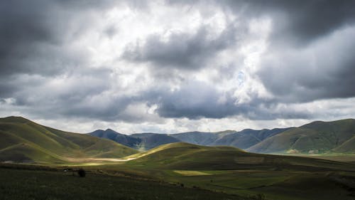 Montagna Di Erba Verde Sotto Il Cielo Grigio