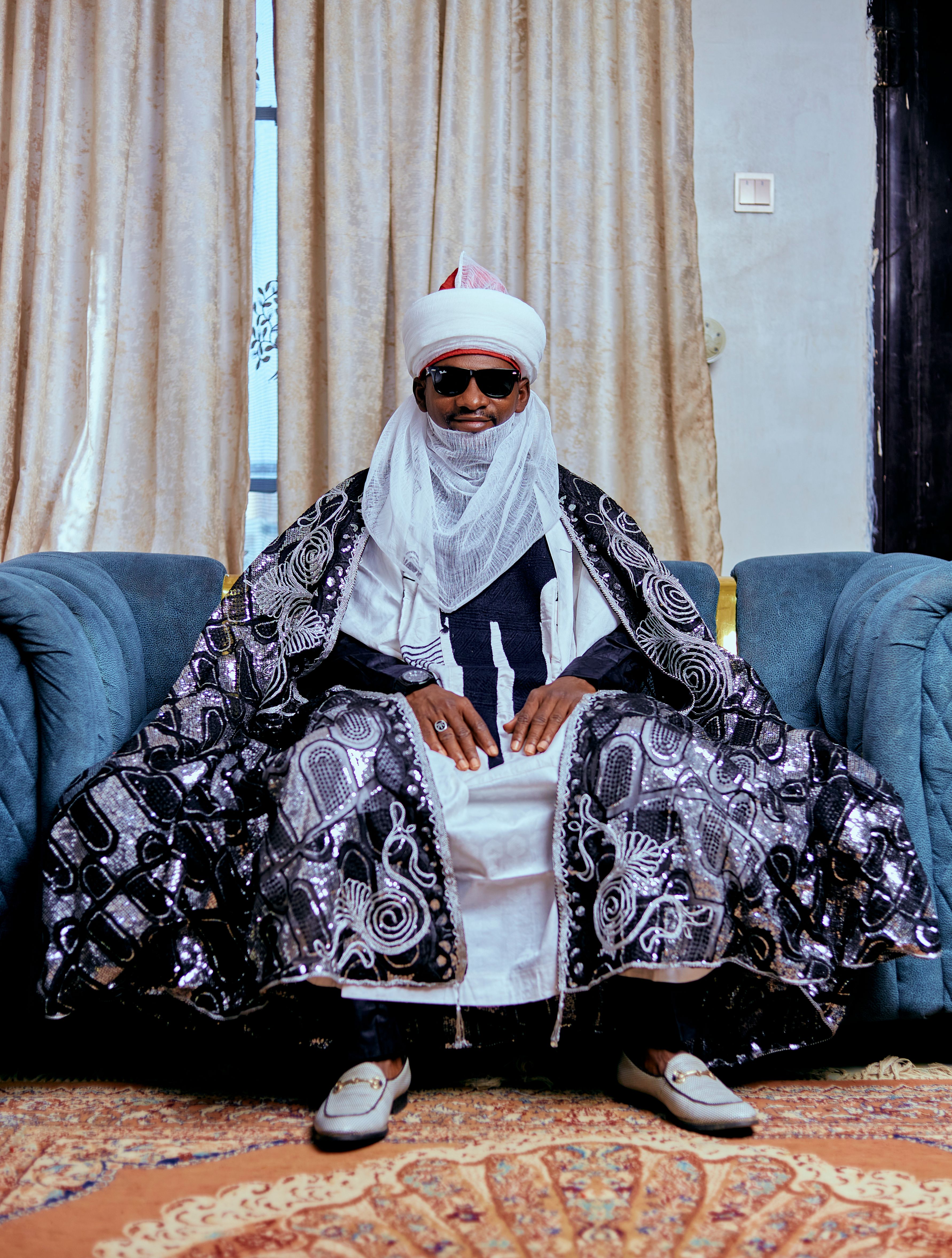 Majestic portrait of a man in ornate traditional attire, seated indoors.