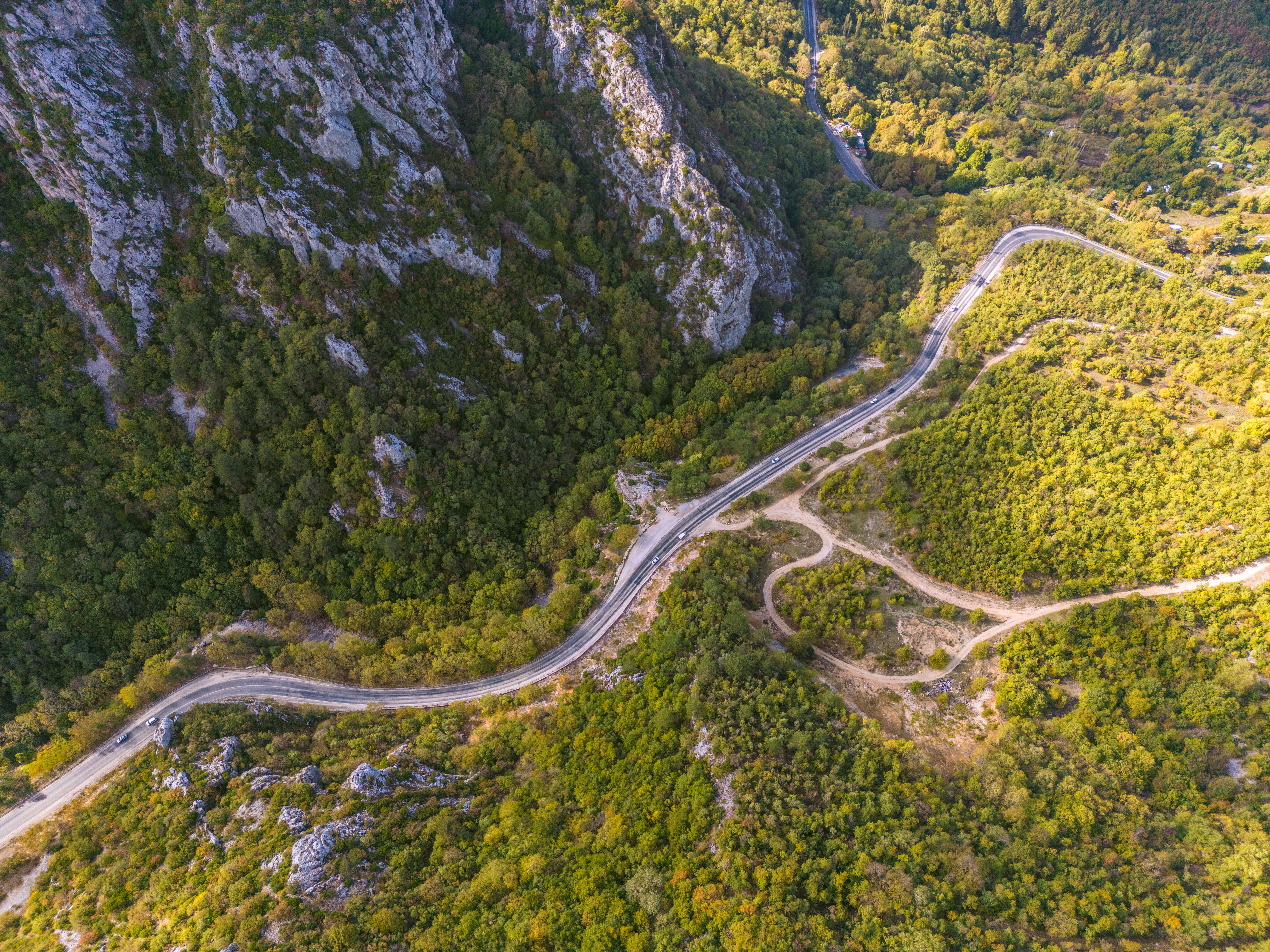 Scenic aerial shot of a winding road through lush forest in Orhaneli, Bursa, Türkiye.