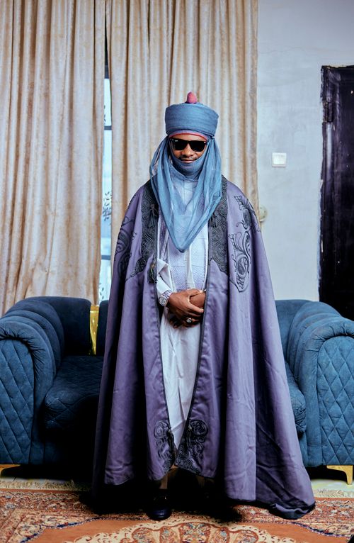 Free An emir clad in traditional attire exudes regal presence in a well-furnished room. Stock Photo