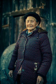 一位穿着圆点夹克的资深女性站在户外，展现出智慧与温暖