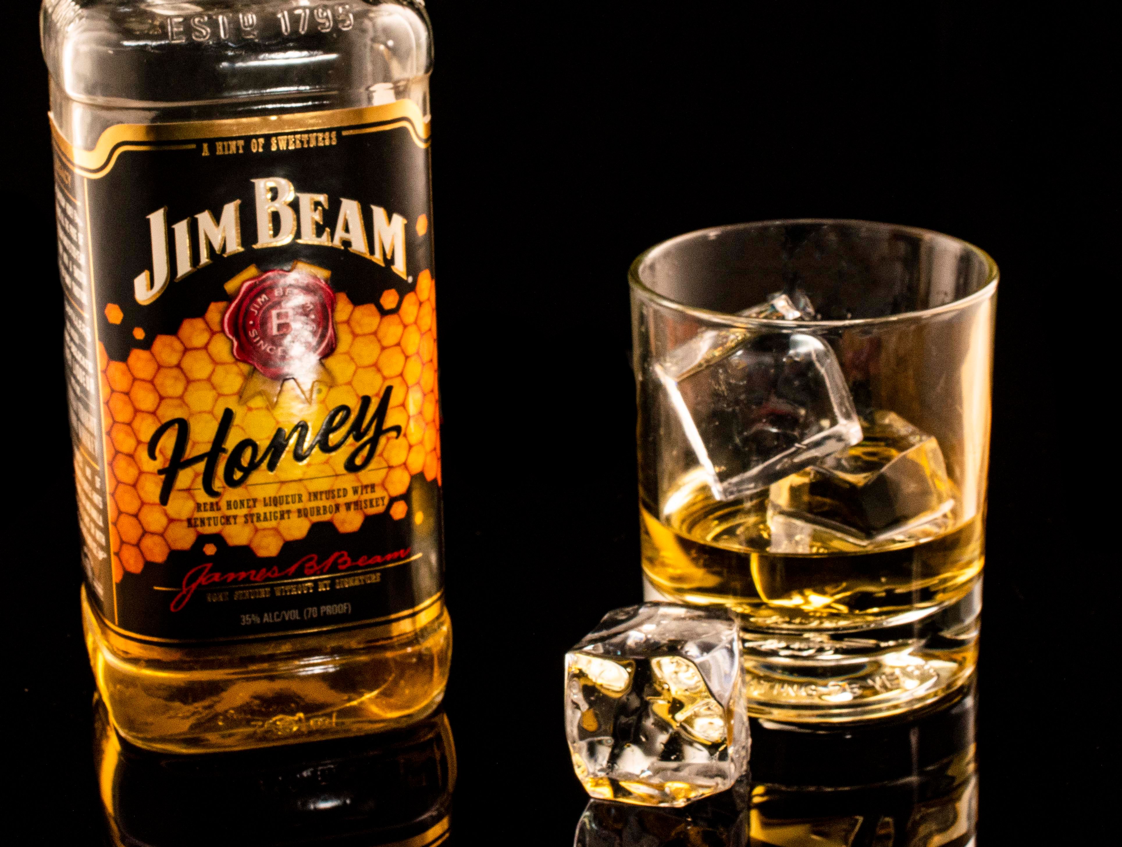 Glass of pineapple flavored Jim Beam bourbon with fresh pineapple slices