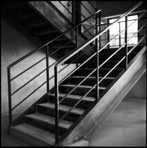 Free Black and white image of an industrial staircase with sleek metal railings. Stock Photo