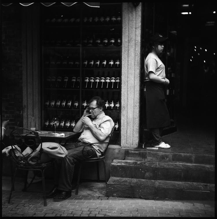 Man Having A Smoke In Front Of A Liquor Store