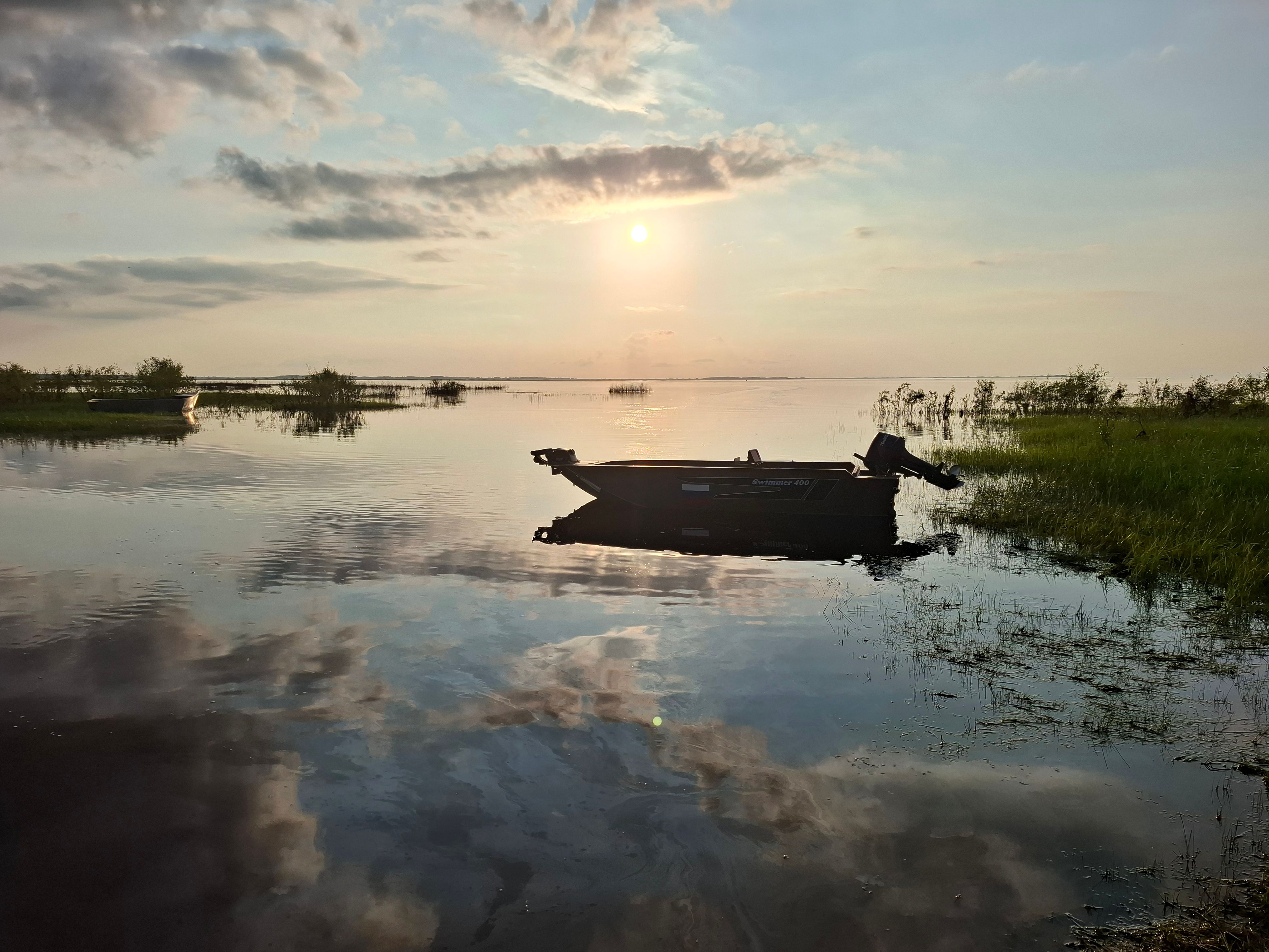 Tranquil Sunset Over Serene Lake with Boat · Free Stock Photo