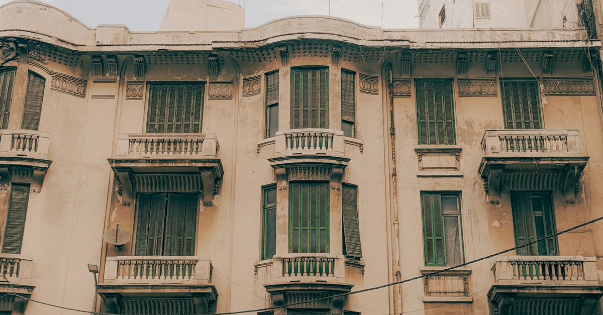 Vintage architecture with distinctive green shutters on an old building facade.
