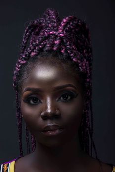 Striking studio portrait of a woman with purple braided hair against a dark background.