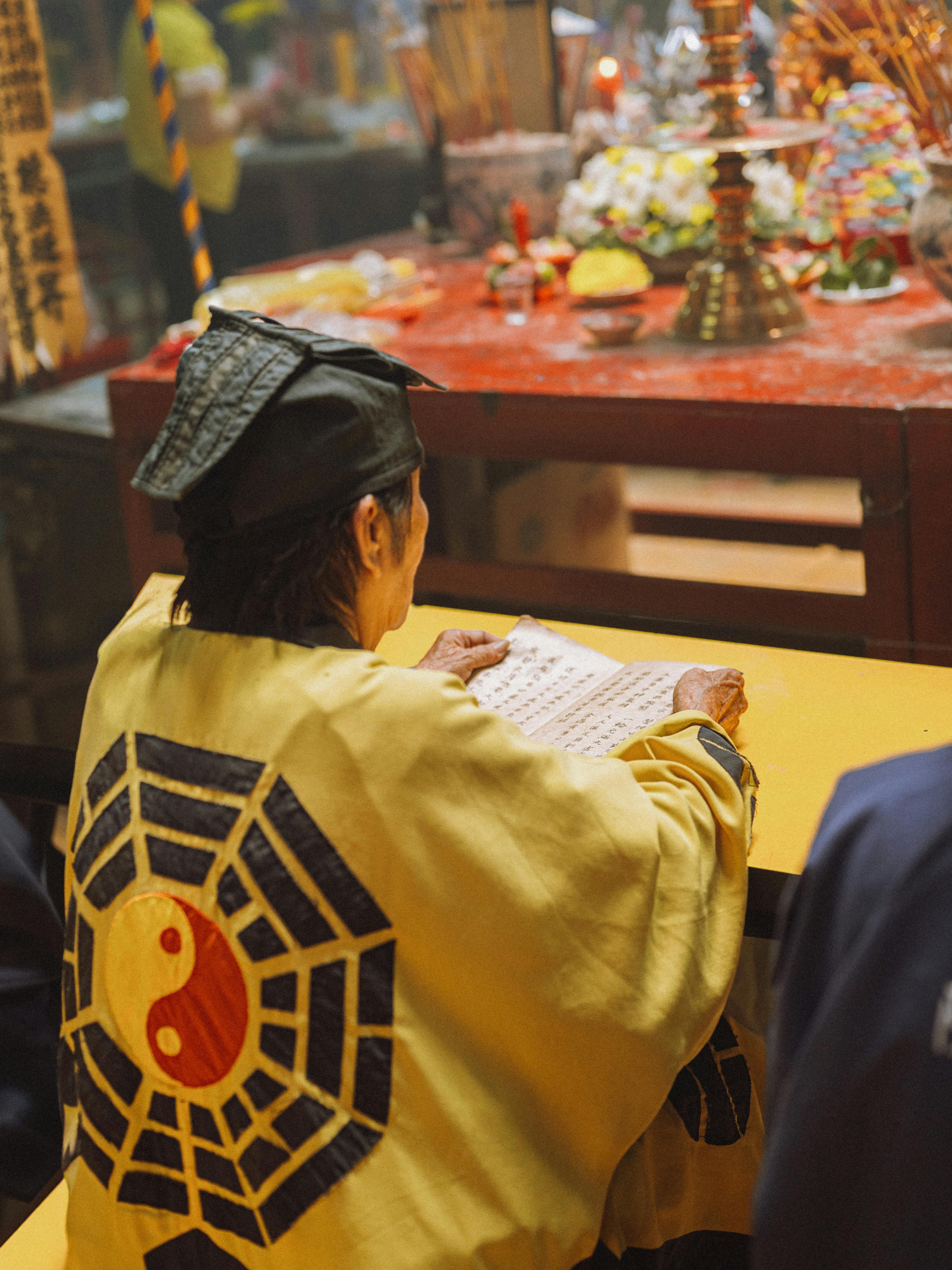 A serene moment captured during a Taoist prayer ceremony, featuring traditional attire and offerings.