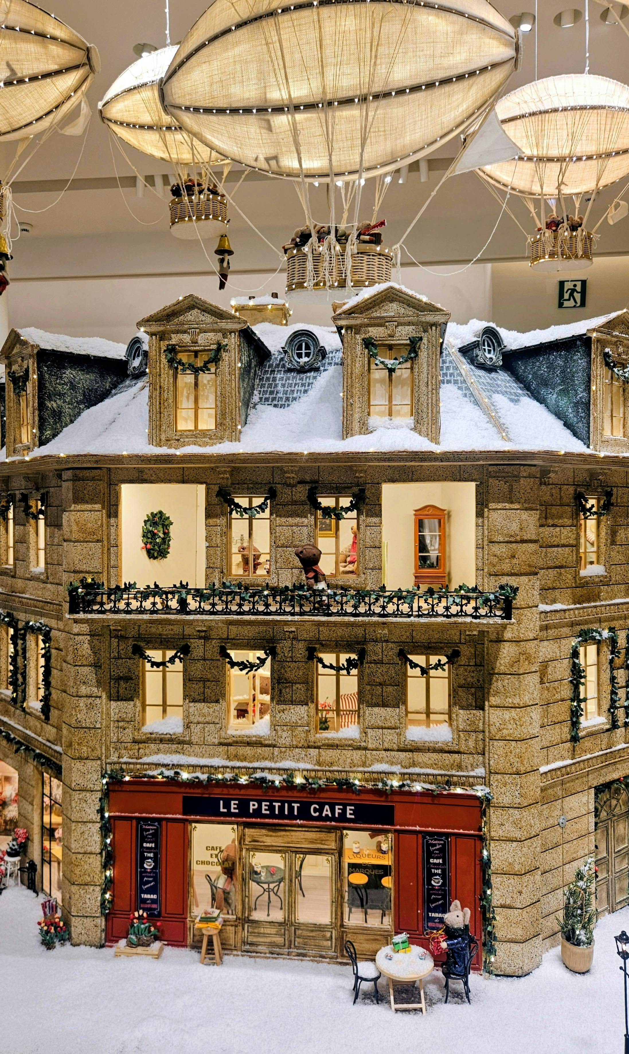 De franc Encantadora escena d'hivern en miniatura amb cafeteria i decoracions de globus penjants. Foto d'estoc