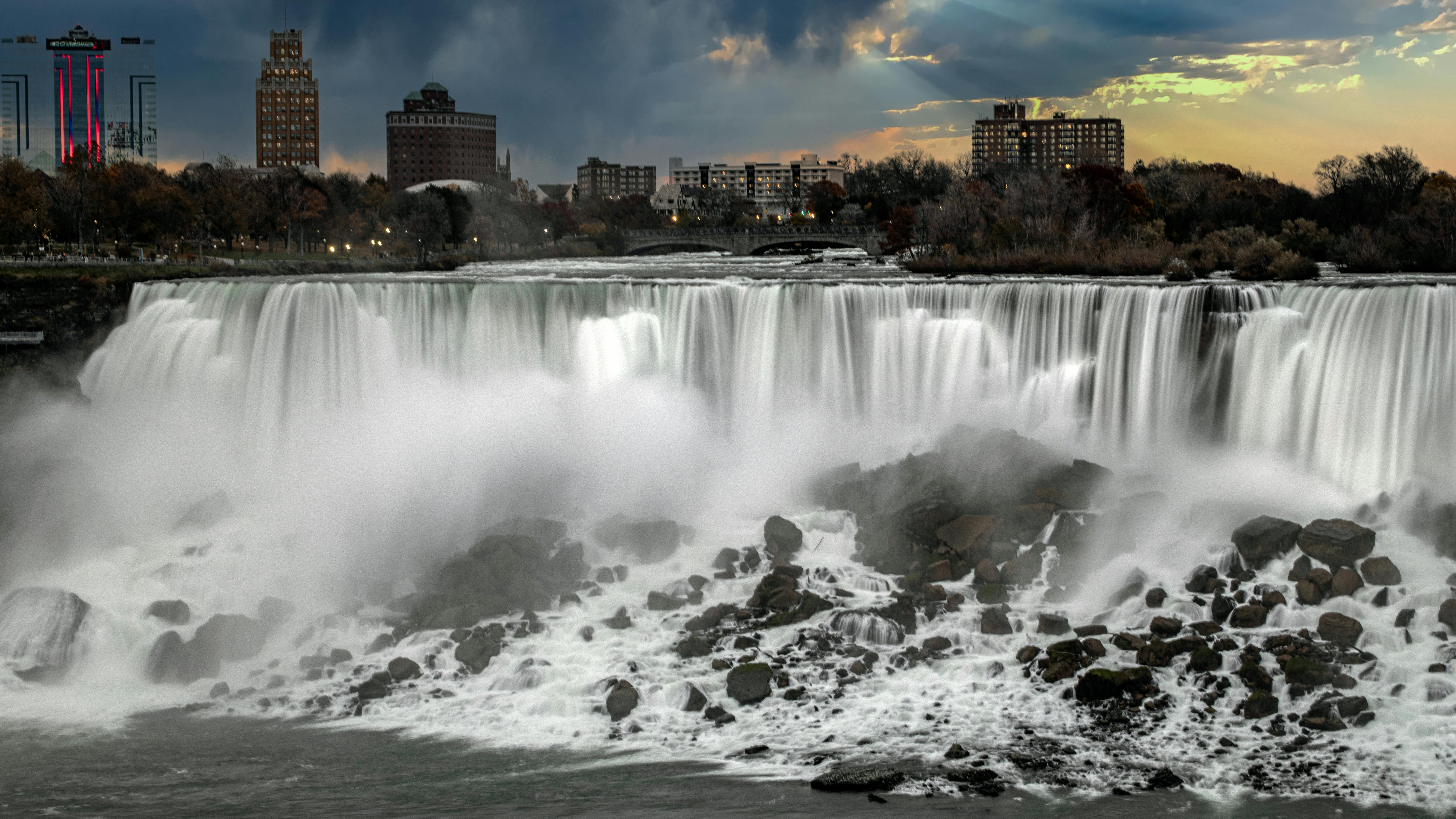 Stunning view of Niagara Falls with a cityscape backdrop at sunset.