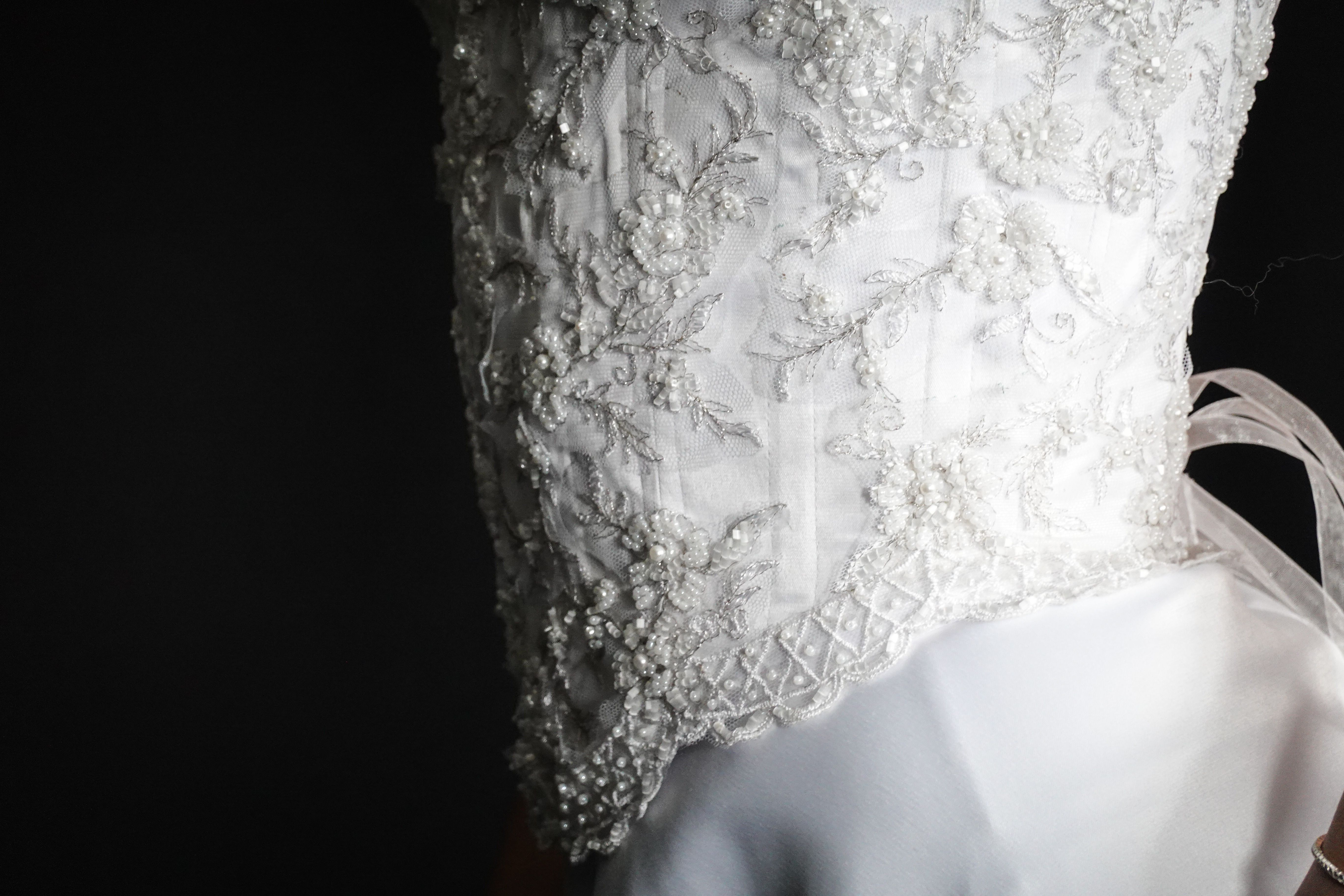 A beautifully redesigned bridal gown displayed on a mannequin in a studio