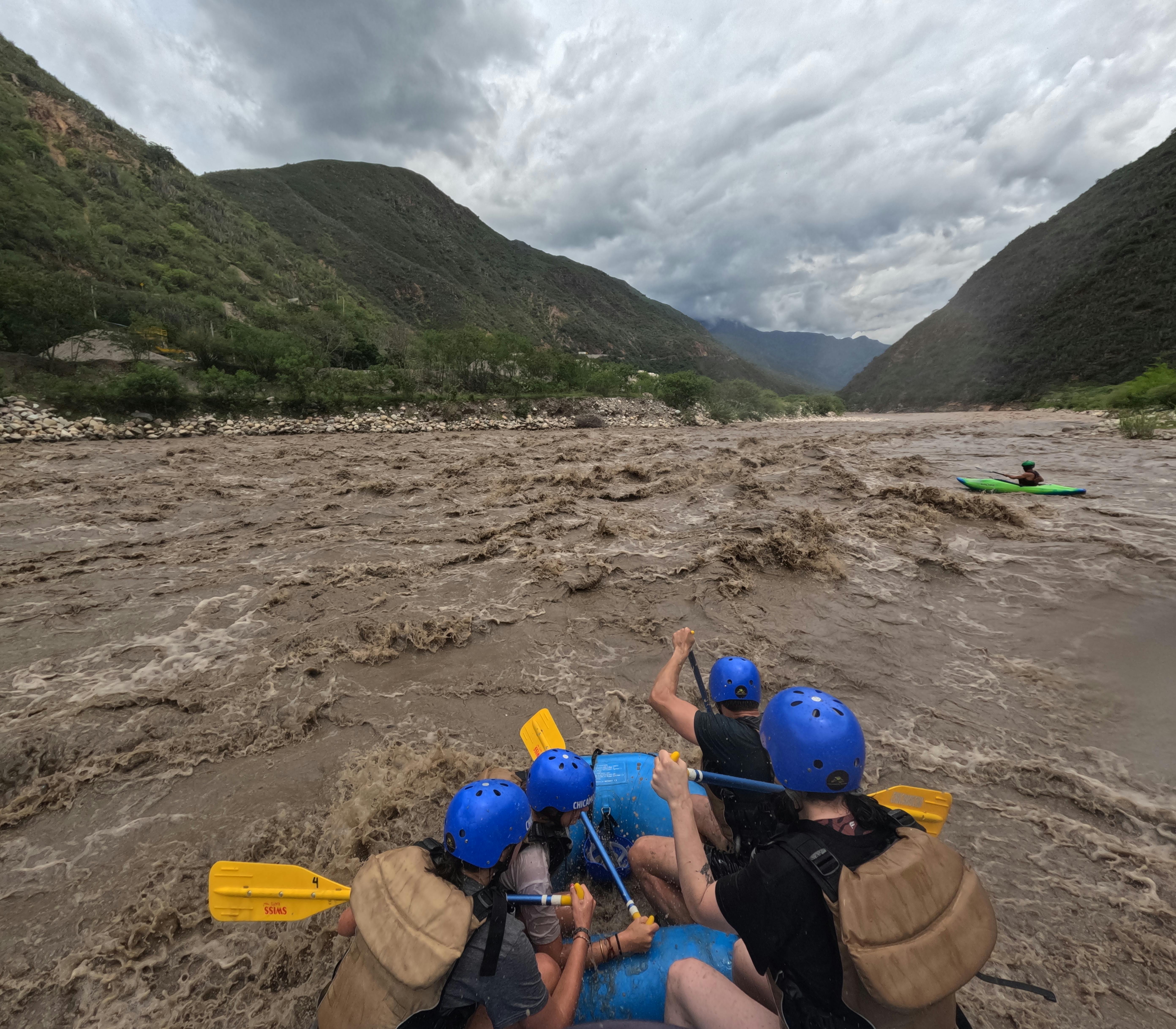 Group enjoying an adventurous whitewater rafting experience in turbulent river rapids.
