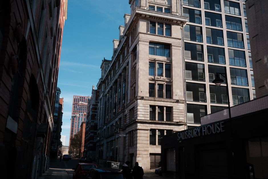 A cityscape featuring historic and modern buildings under a clear blue sky.