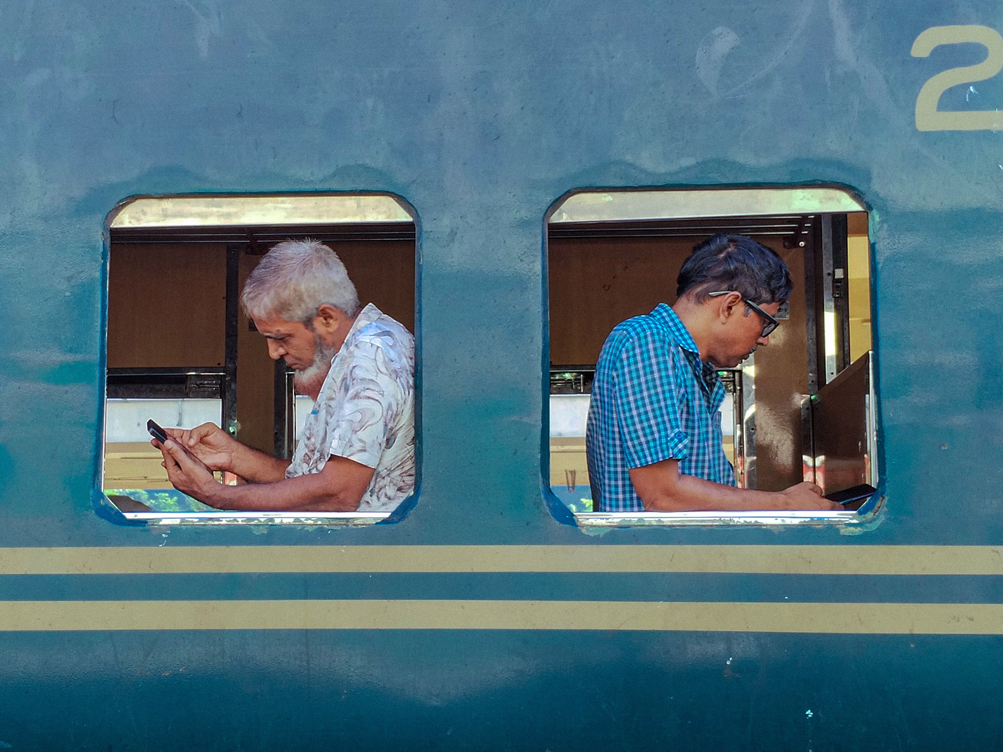 Passengers Using Phones on a Bangladesh Train · Free Stock Photo