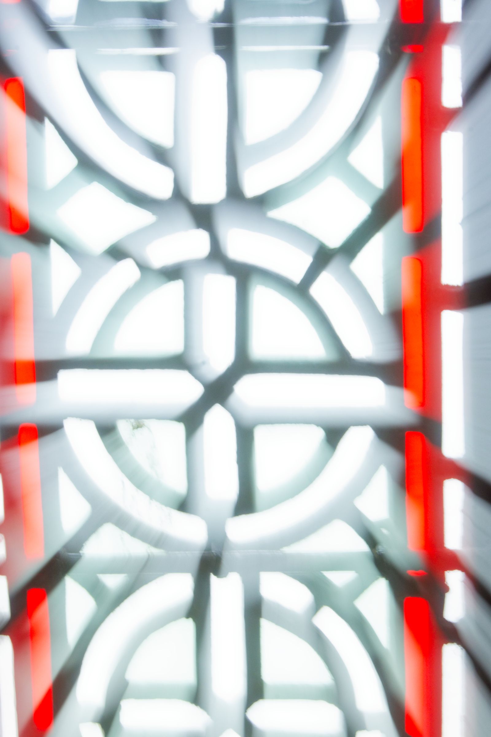 Soft-focus stained glass with circular arcs framed by red strips