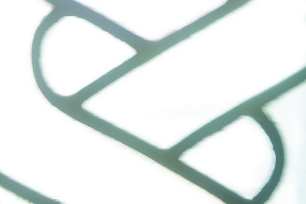 Gros plan minimaliste de plombs courbes sur un vitrail blanc