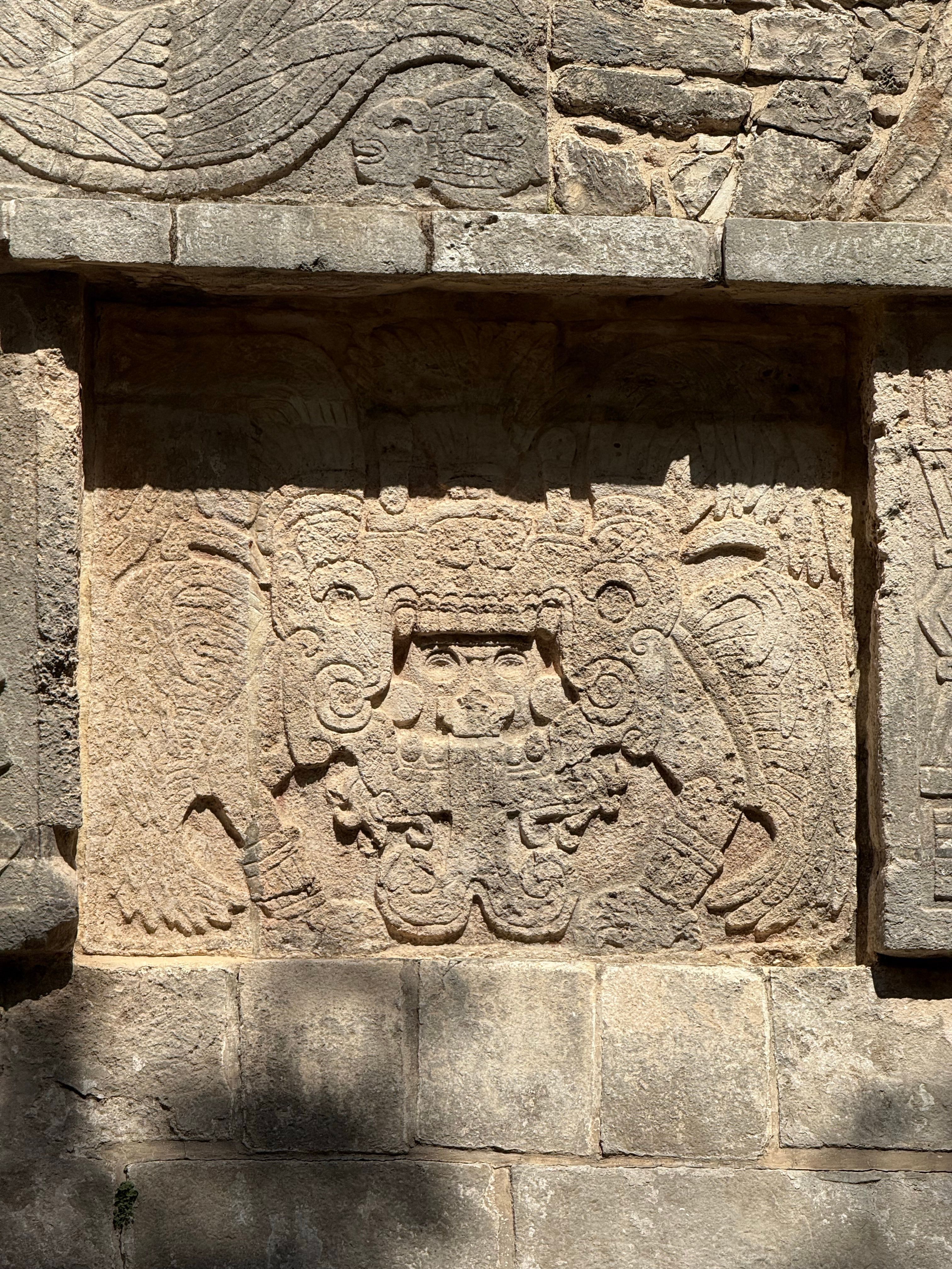 Detailed Mayan stone carving under sunlight at historic site, showcasing ancient art.