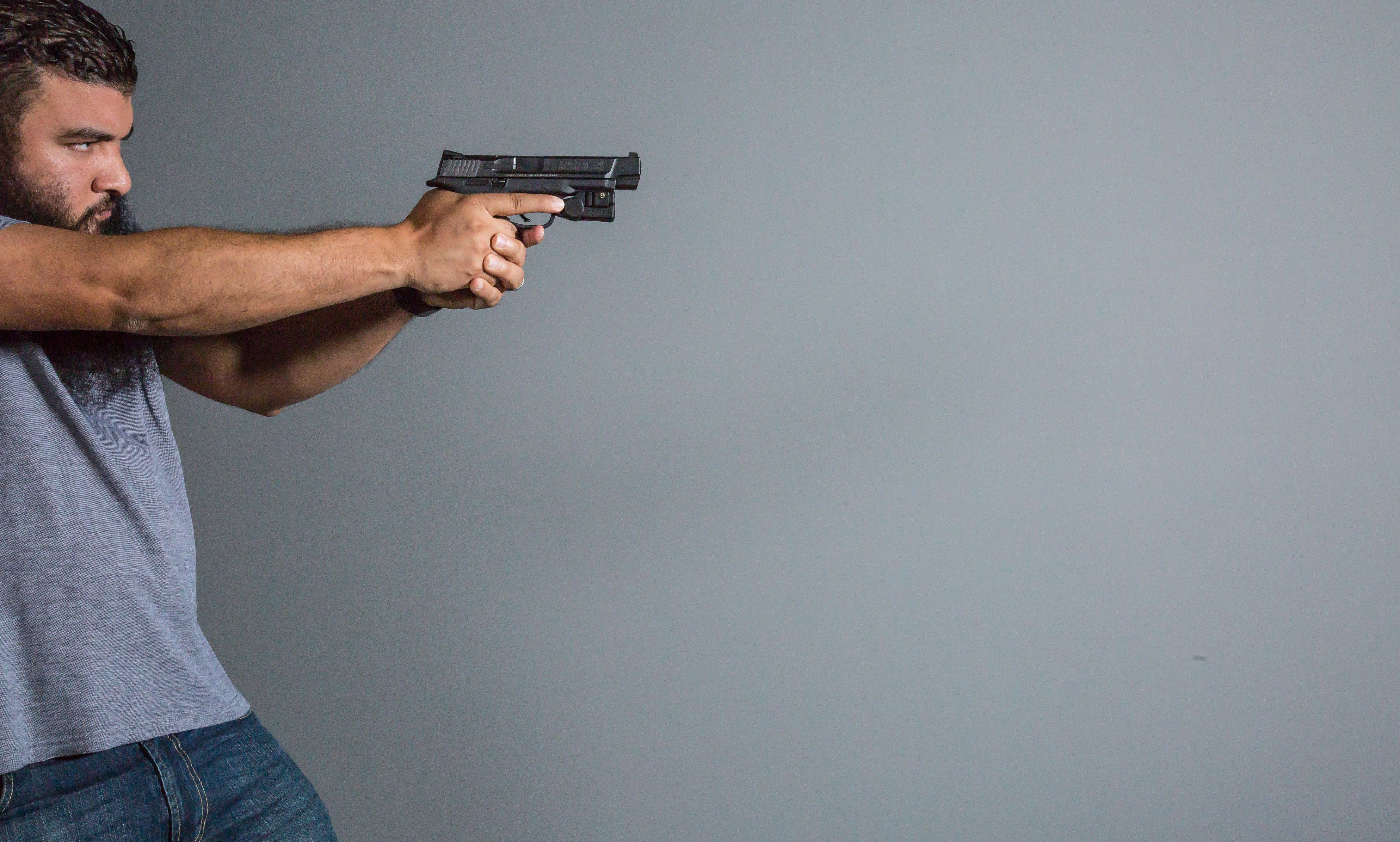 Man Pointing Gun in Shooting Stance · Free Stock Photo