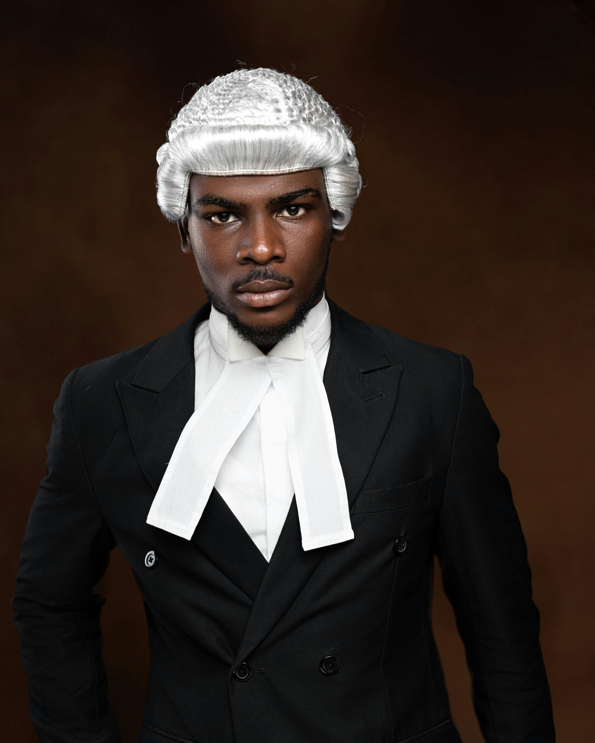 Professional portrait of a lawyer wearing a traditional barrister's wig and gown, conveying authority.