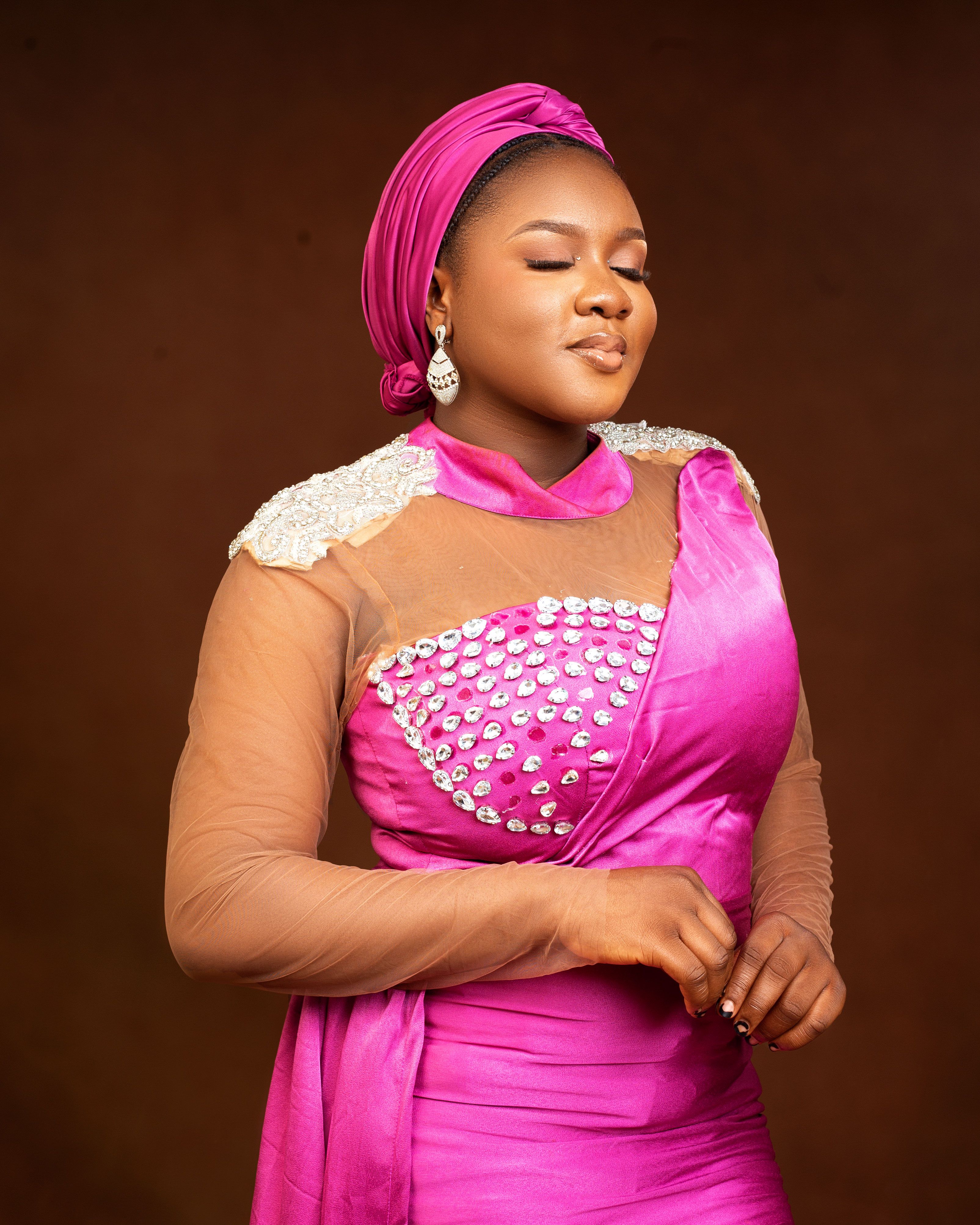 Portrait of a woman in pink traditional dress with closed eyes, serene expression.