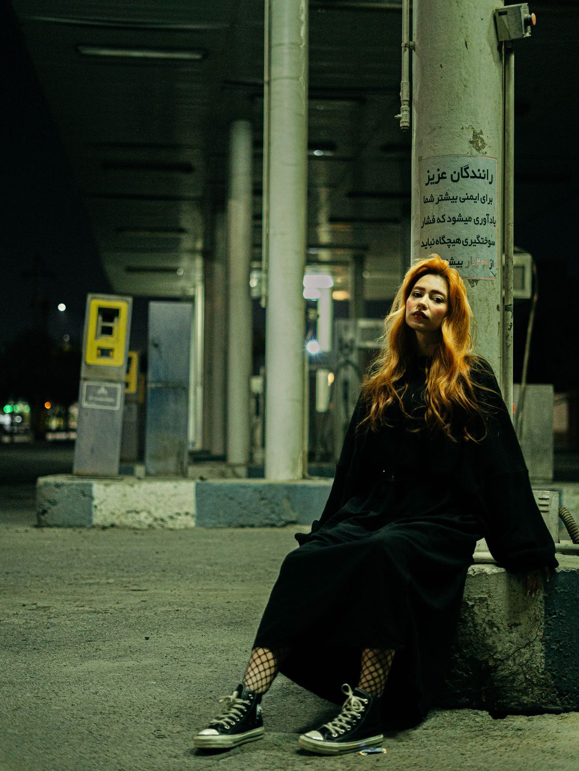 Young woman sitting at night in urban setting · Free Stock Photo