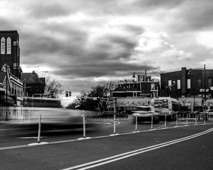 Blurry black and white cityscape showing motion, street traffic in Somerville.