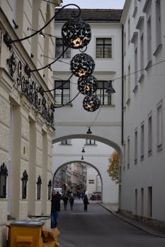 Cozy European street with decorative lanterns and archways, perfect for travel inspiration.