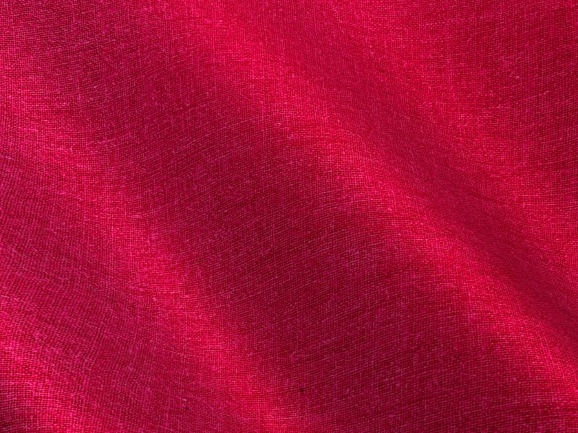 Vải linen màu đỏ đô với nếp gấp tự nhiên, thể hiện độ bắt màu và bề mặt đặc trưng của sợi lanh