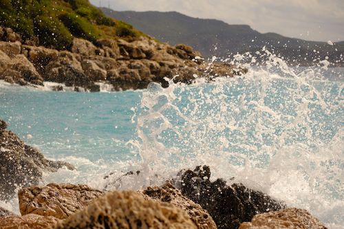 Free Dynamic capture of ocean waves crashing onto a rocky shoreline under a clear sky. Stock Photo