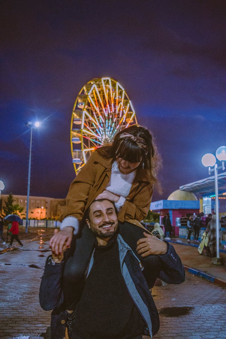 Man Carrying Her Girlfriend On His Shoulder