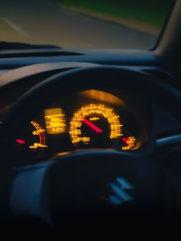 Close-up of a car dashboard glowing during nighttime drive.