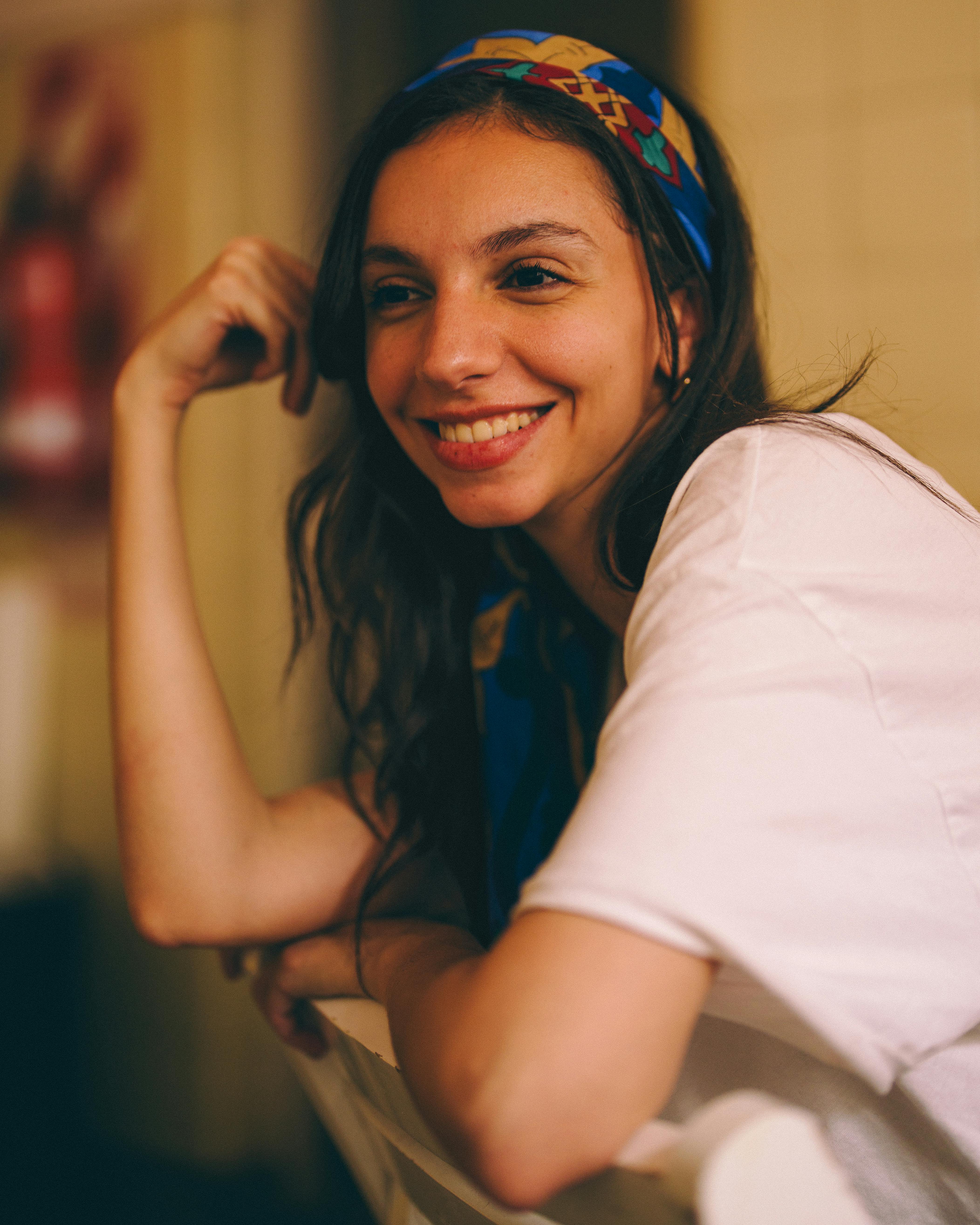 ingyenes Ellazult, mosolygós nő fejkendővel, a korlátnak támaszkodva bent. Stockfotó